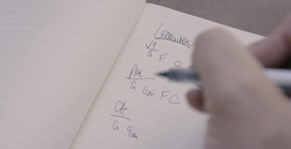 Person writes in a notebook with a pen