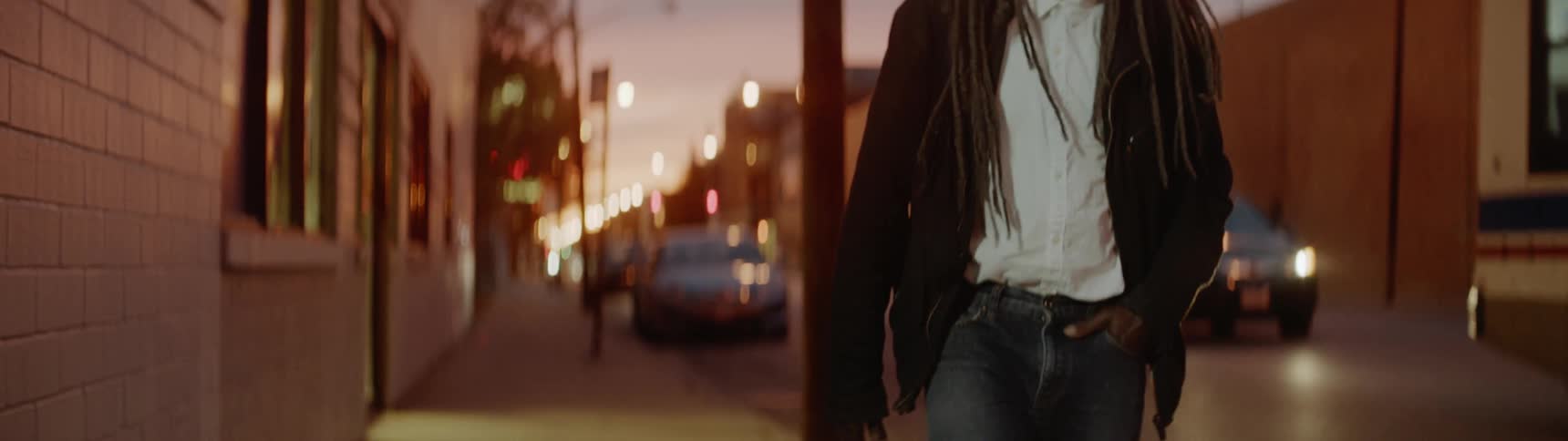 Man walks down the street and a bus drives past him