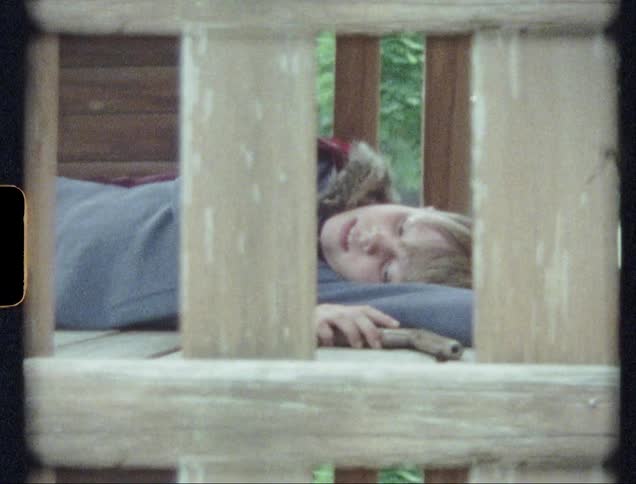Child lays on the floor of a tree house