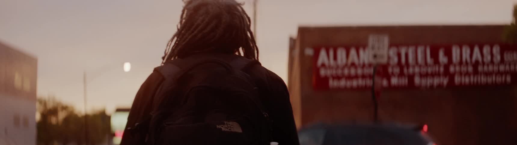 Man walks in the city at sunset