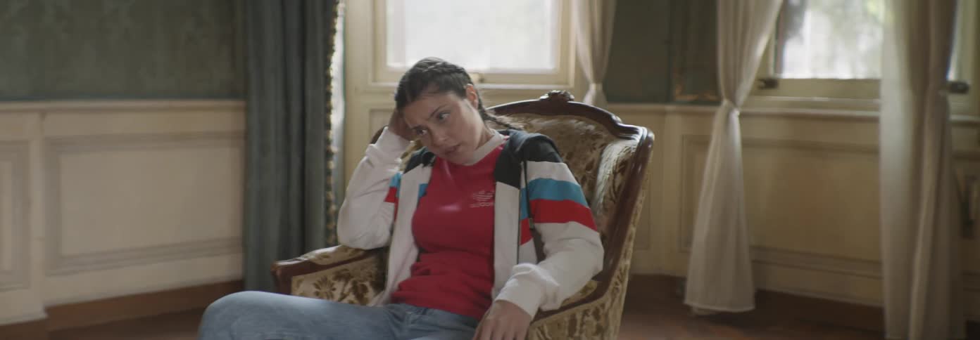 A woman sitting in a chair looks around the room