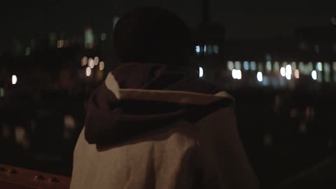 A man looking out over a cityscape at night