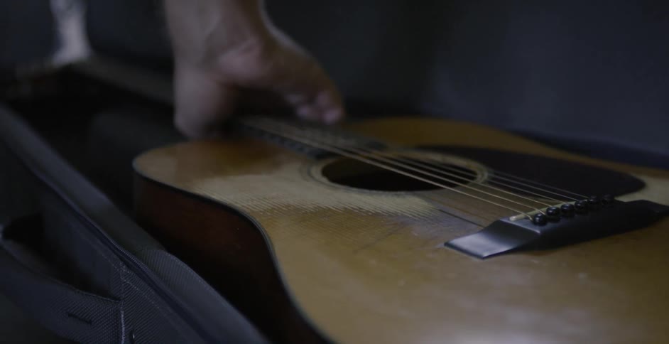 Person takes a guitar out of its case