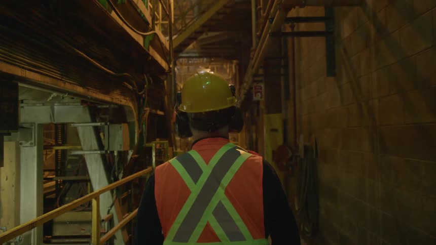 A construction worker walks in a warehouse