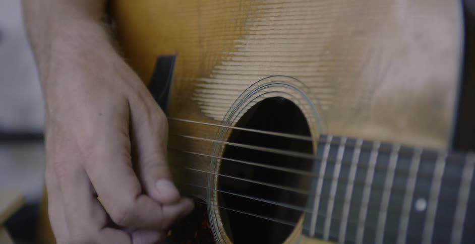 Man strums guitar