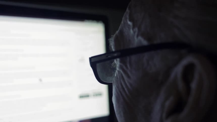 An elderly man uses a computer