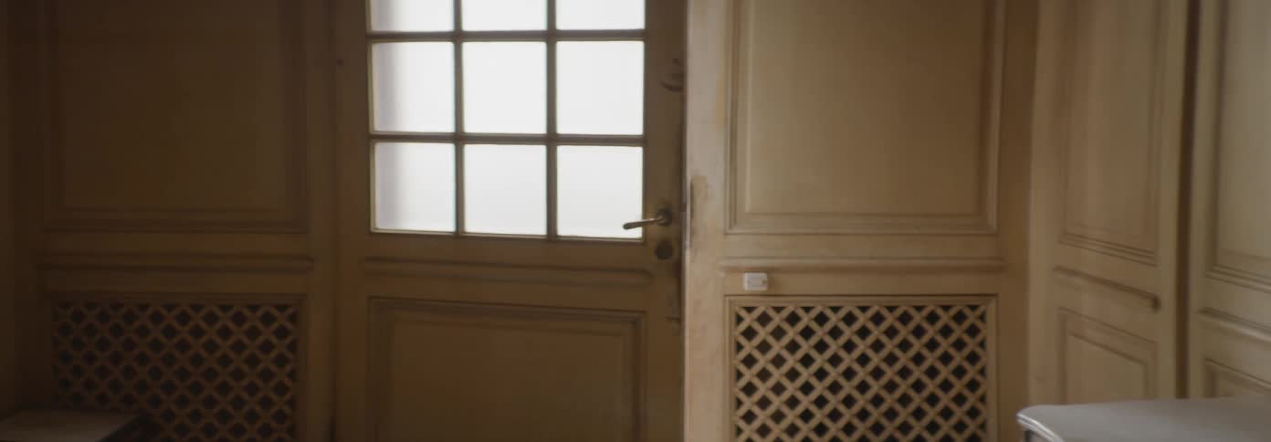 A front door to a house stand ajar inside during the day