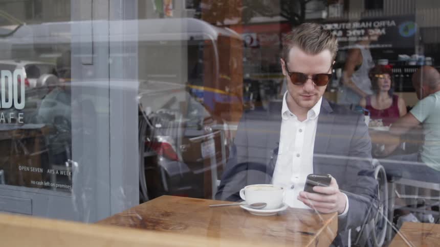 Man sits in cafe texting