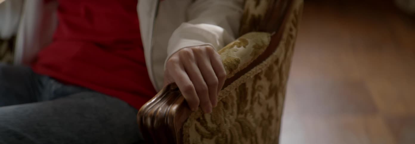 Woman grips the armrest of a chair