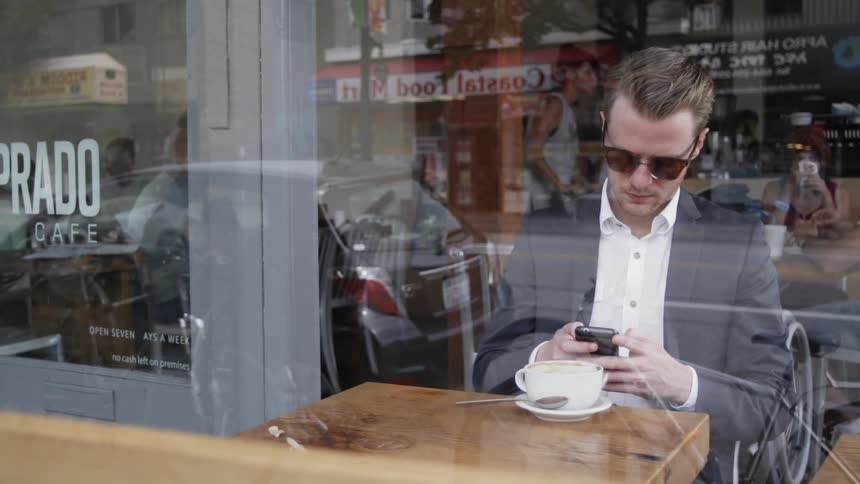 A man sits at a coffee shop table