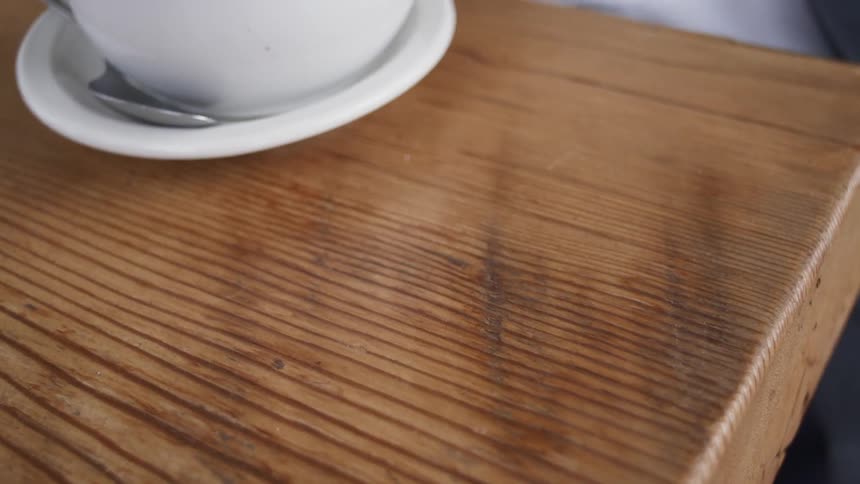 A man grabs his phone at a coffee shop