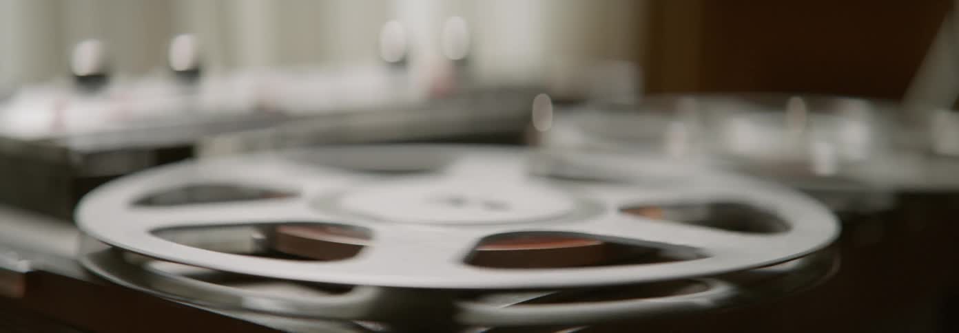 The reels on a tape deck are spinning inside in daylight