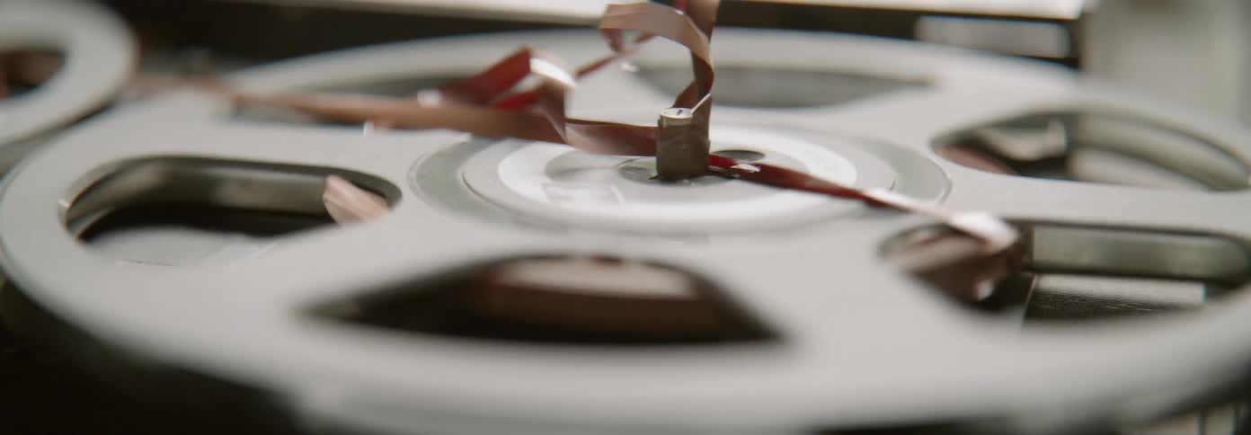Person picks up tape from a reel as it spins around