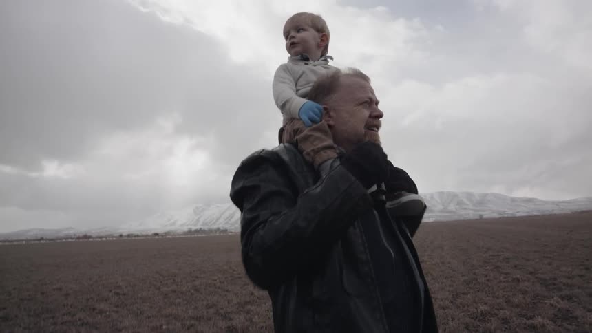 A man carries a young child on his shoulders