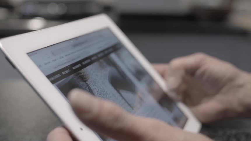 Person holds a tablet scrolling through pictures