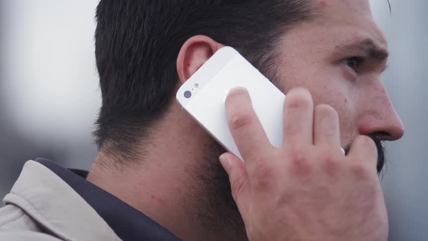 Man talks on a cell phone outside