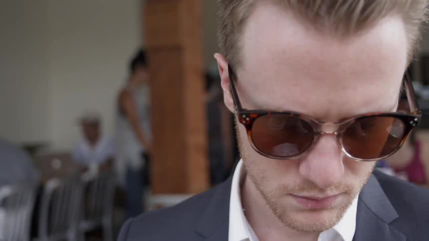 Man wears sunglasses and a suit