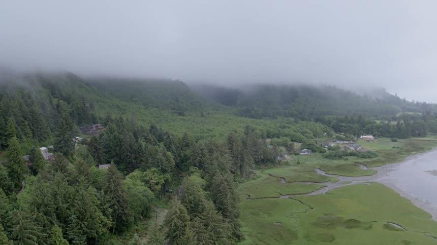 Fog rolls over grassy hills near a river