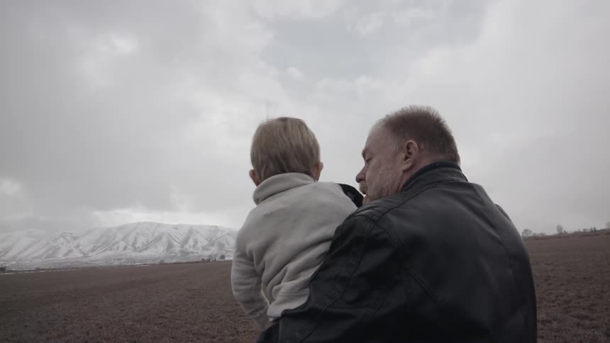 A man uses binoculars with a young child