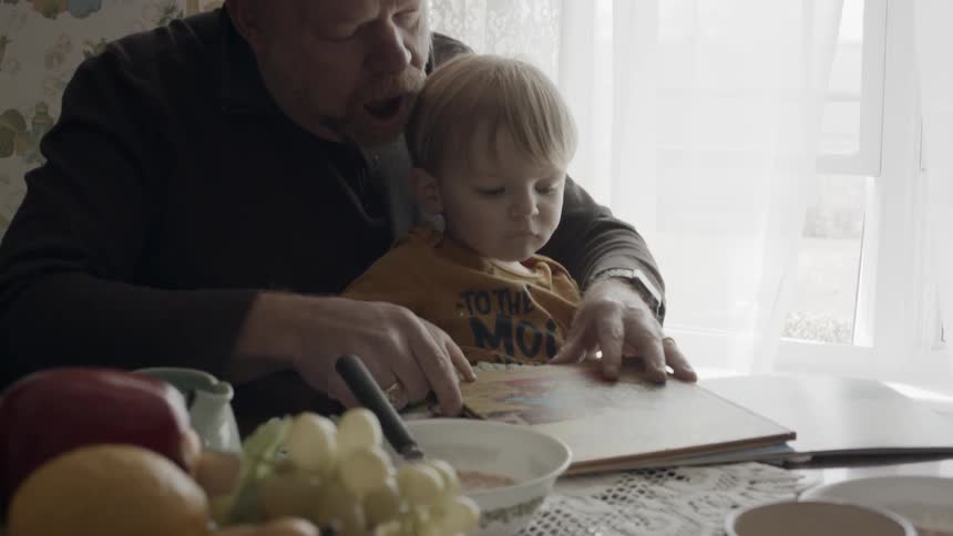 A man shows books to a young child