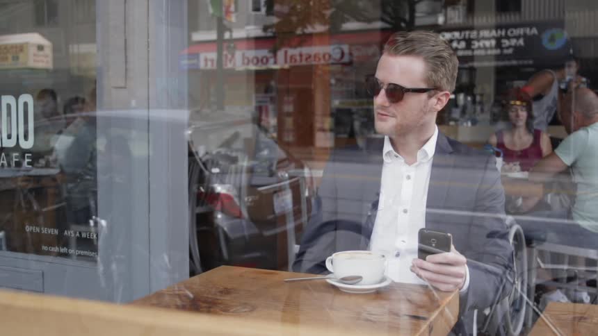 Man sits in cafe texting