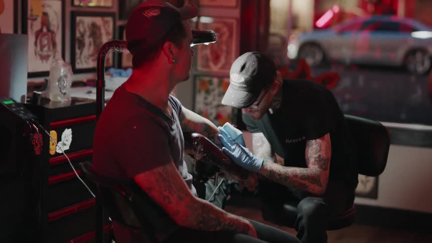 Man gets a tattoo in a tattoo parlor