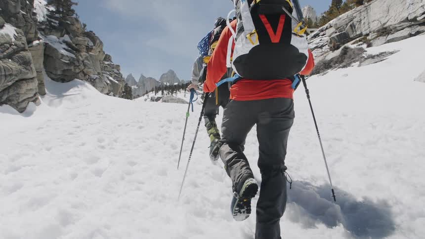 Climbers use ski poles to help walk up the snowy slope