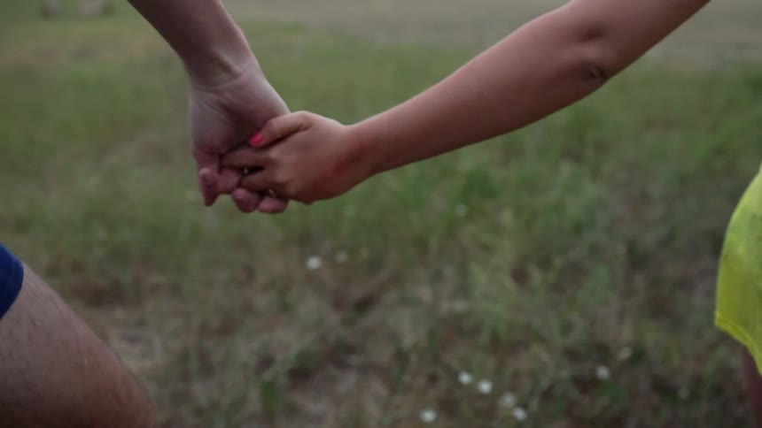 Two people hold hands and walk together
