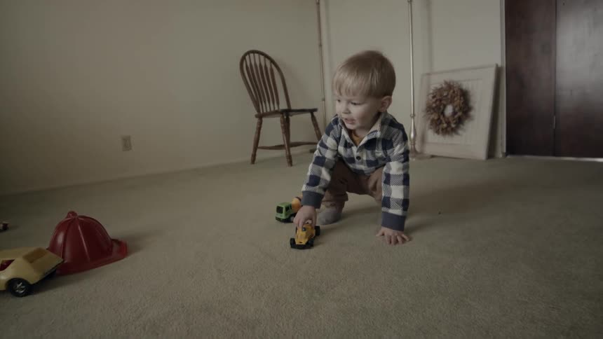 The child is playing with toys in the room