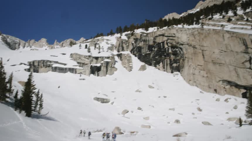 A group of people hike up a snowy mountain