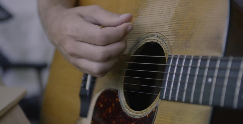 Man plays a guitar with his fingers