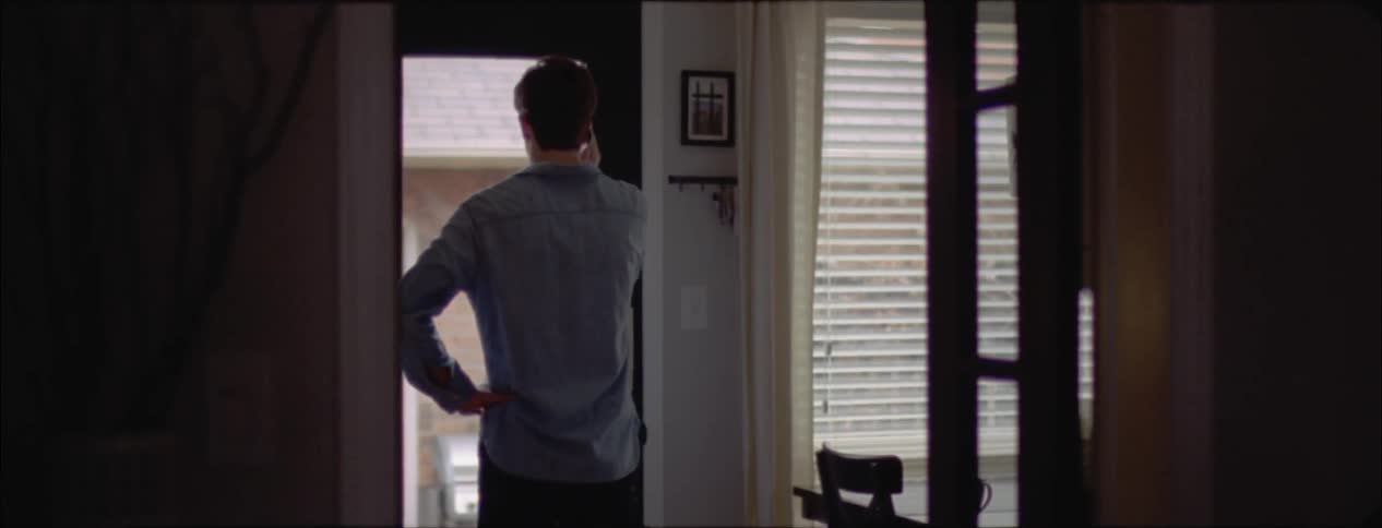 Man talks on a phone by a doorway