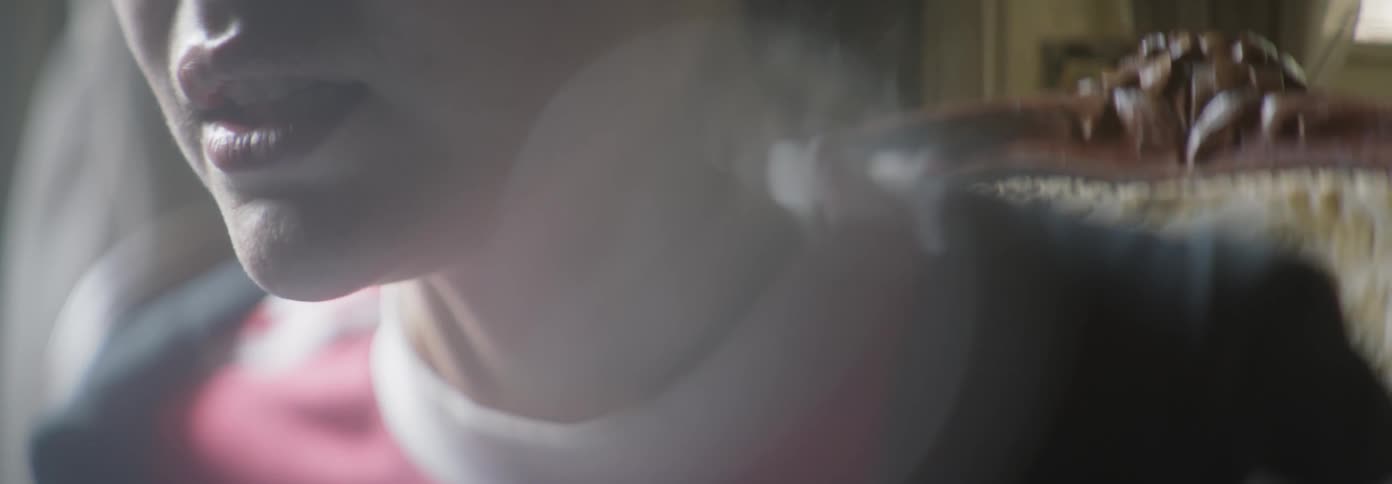 A girl is breathing heavy as she sits in a chair in a room in daylight
