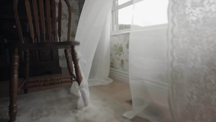 The wind blows white curtains in the house