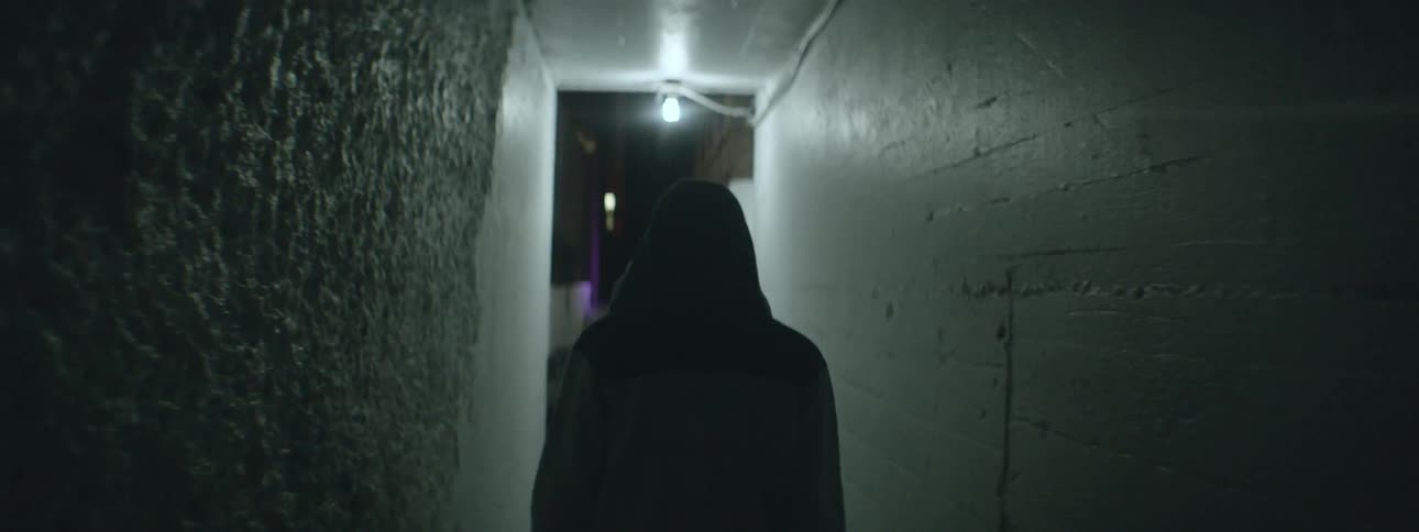 A person walking down an alley at night