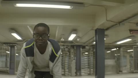 A young man dances in an empty subway station