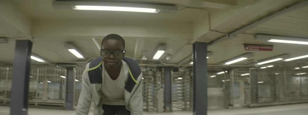 A young man dances in an empty subway station