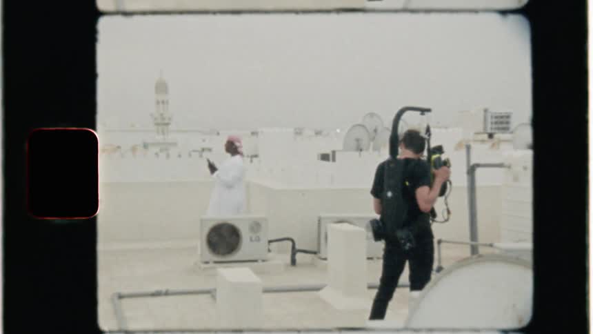 A middle eastern man is filmed atop the roof