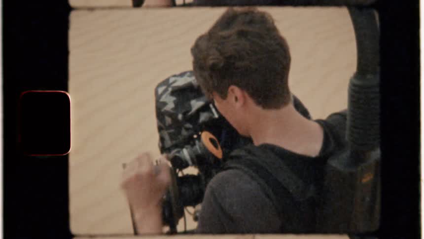 A man films in the desert