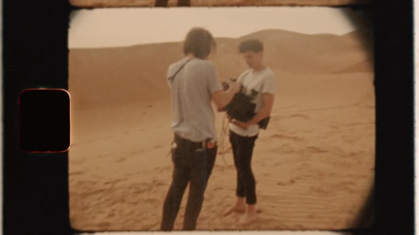A film crew stand around in the desert