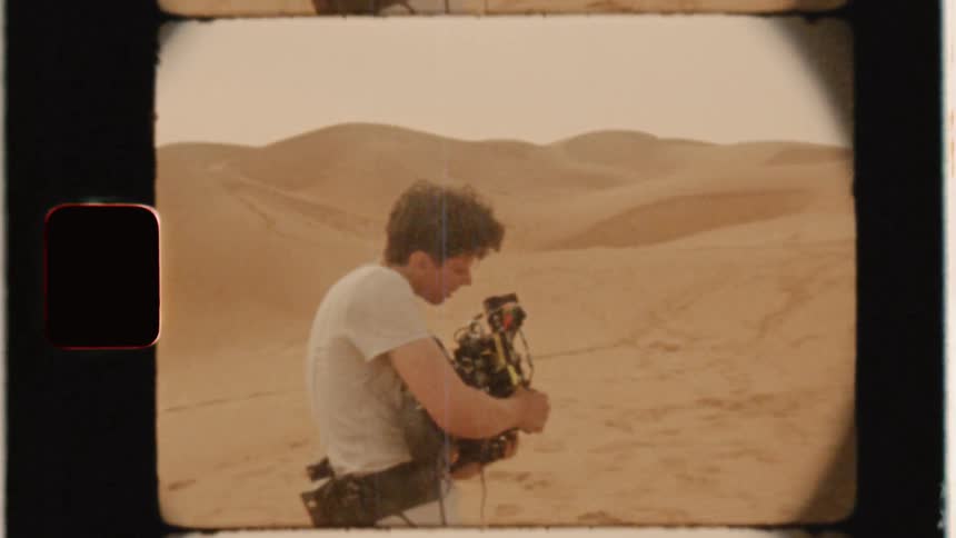 Man films in a sandy desert