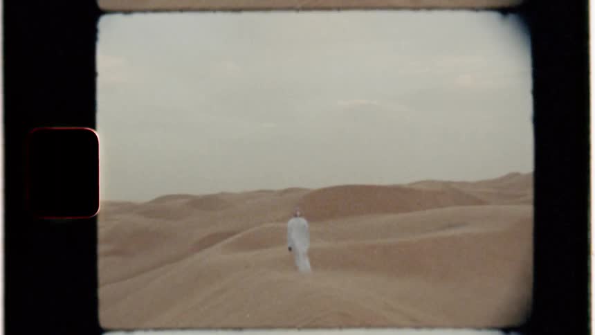 A man walks in the windy desert
