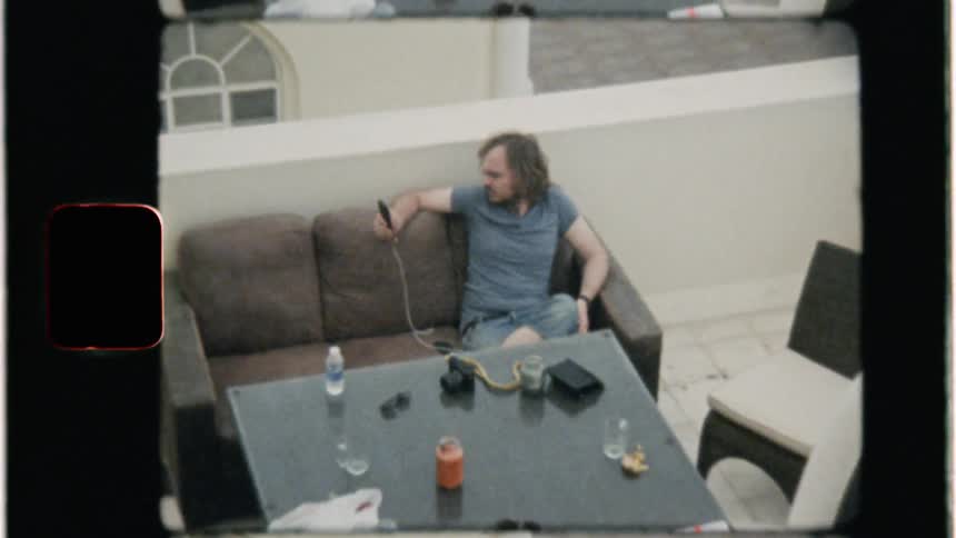 Man looks at his phone while sitting on a couch