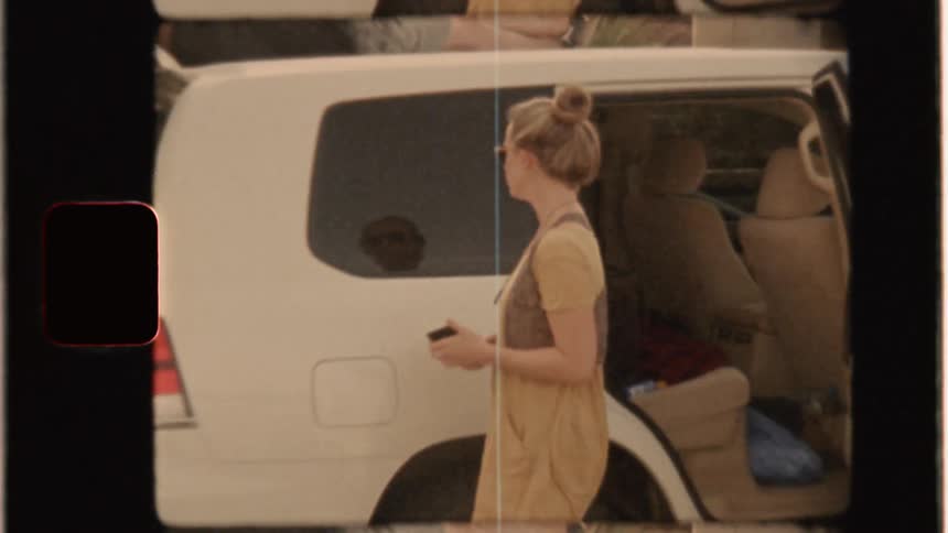 A group of people hang out outside of a car