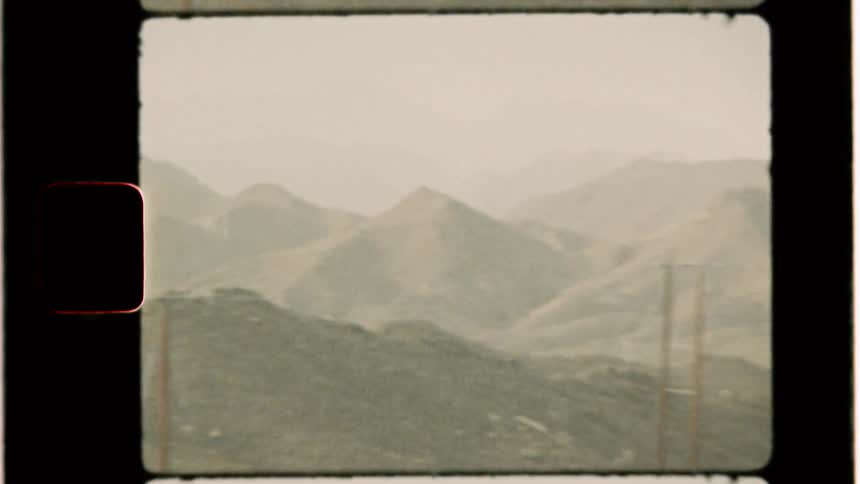 Hills and trees sit under a cloudy sky