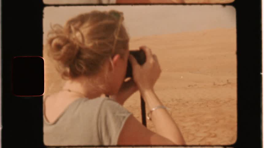 Woman takes a photograph in a desert
