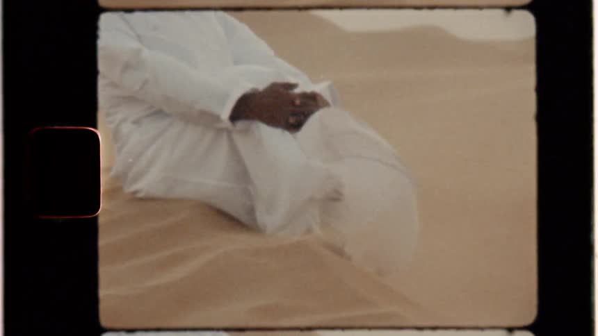A man sits in the windy desert
