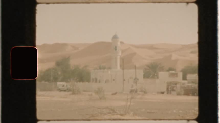 White buildings sit near the desert