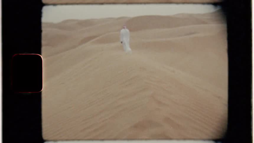 Man stands on a sandy dune in a desert