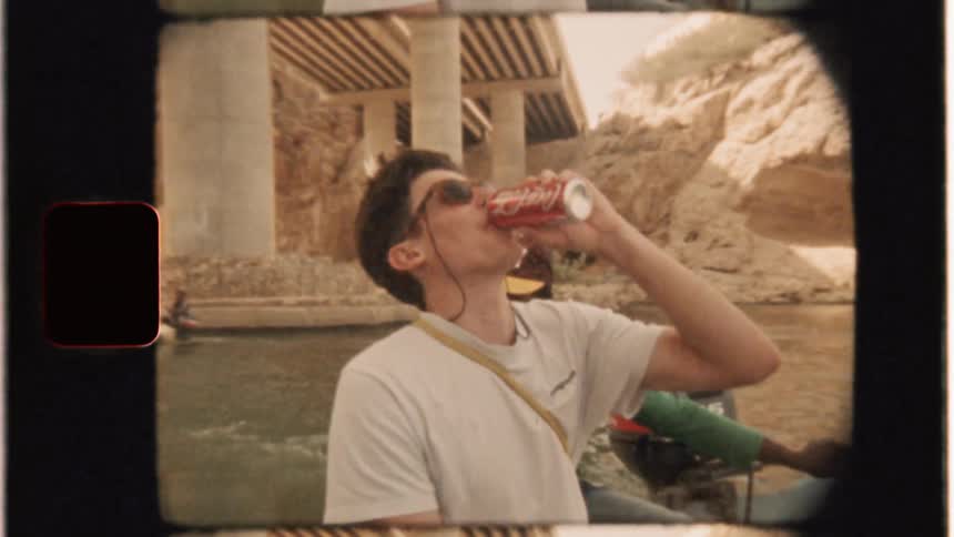 Man drinks coca-cola while riding in a boat